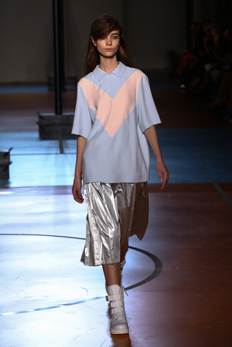 Model walking designer runway wearing pastel polo shirt