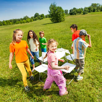 Children go around playing musical chairs outside