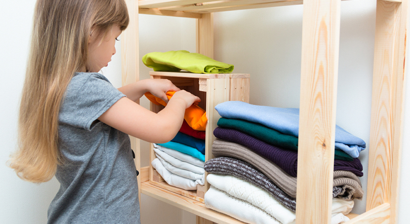 girl sorting laundry in room