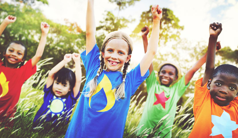 children cheering in grassy field