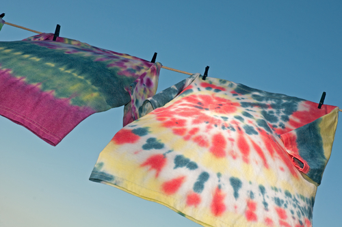tie dyed shirts hanging on clothes line