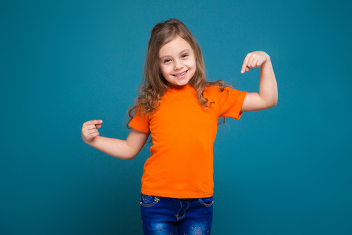 child pointing to her orange t shirt