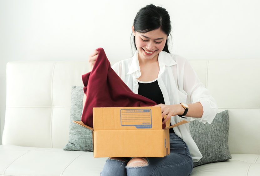 woman unpacking shirt from box