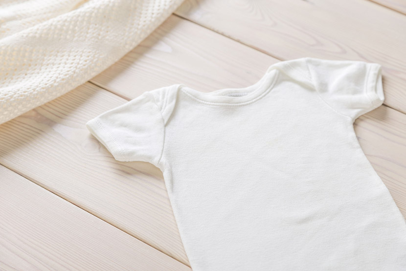 White baby shirt on wooden desktop