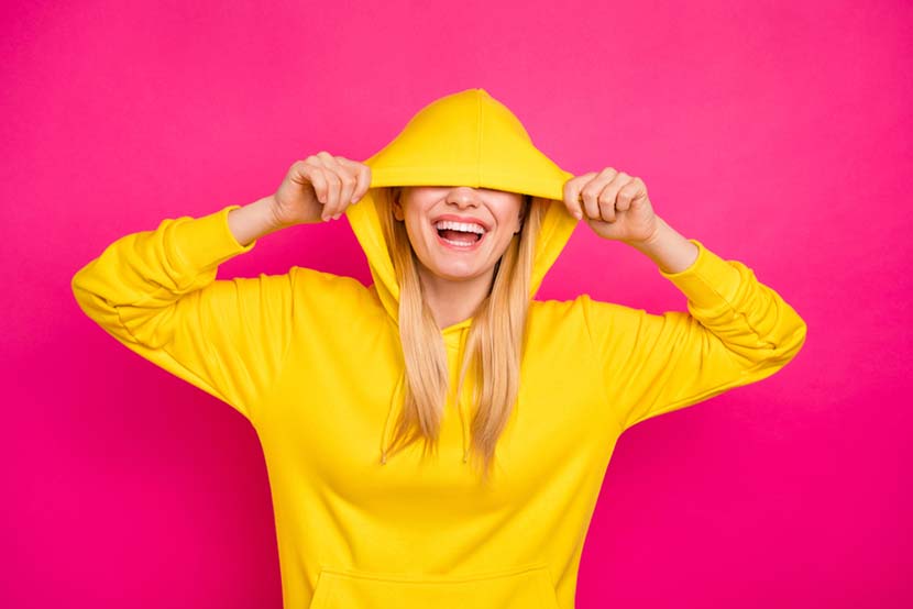 woman pulling down yellow hoodie