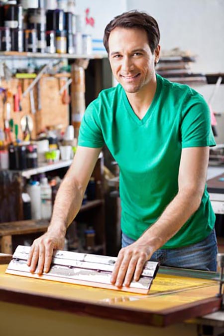 Portrait of confident mid adult worker using squeegee on a silkscreen