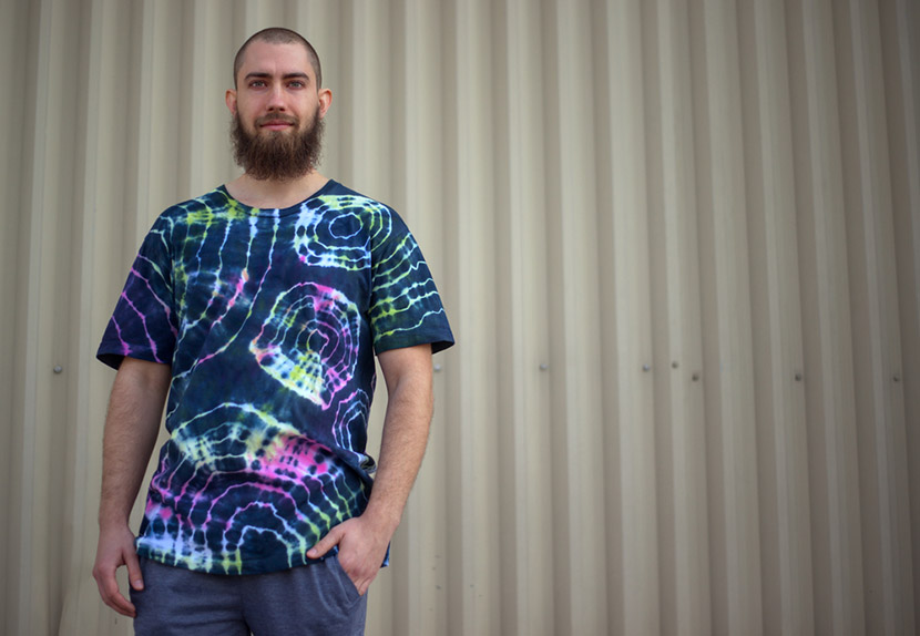 young man with a beard wearing tie and dye psychedelic t-shirt circle pattern