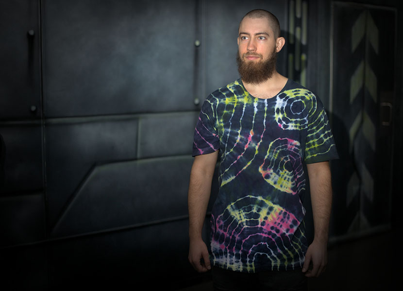 a man wearing a shirt with a reverse tie dye pattern in multiple colors