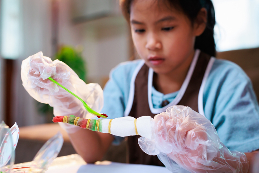 a little girl making a tie dye shirt