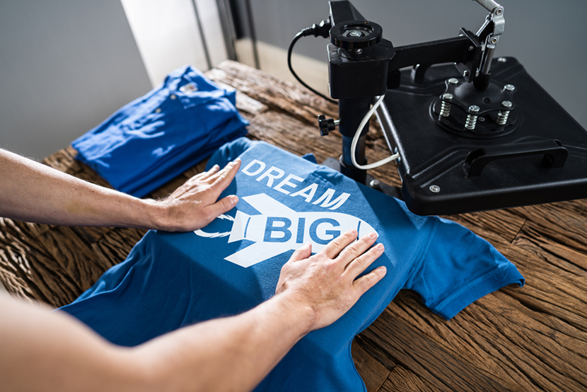a person printing dream big on a t shirt