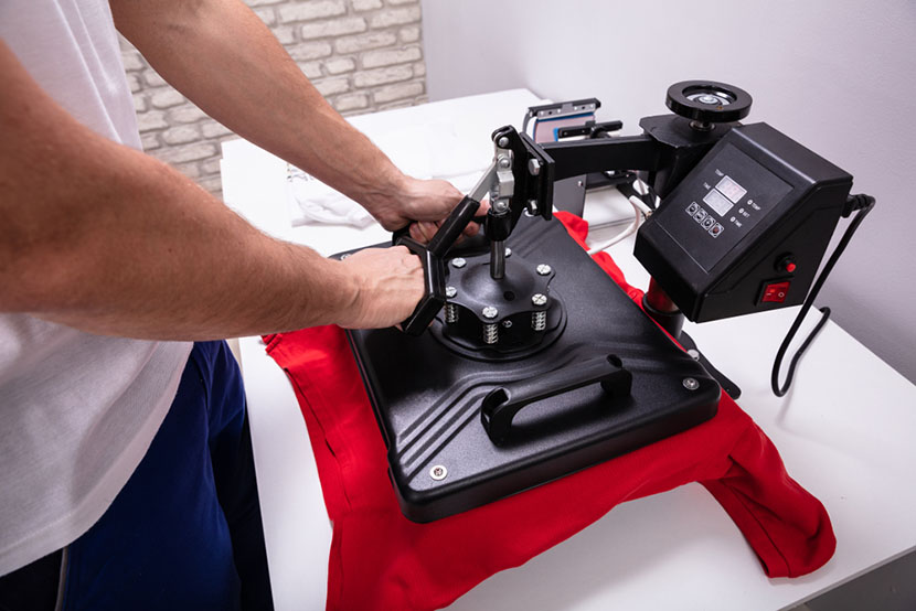 Man printing on t shirt in workshop