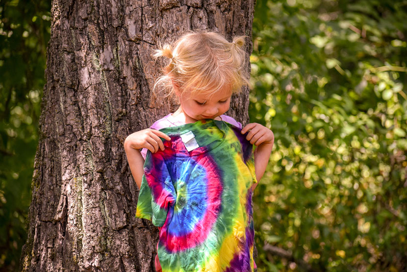 A little girl looking at her tie dye t shirt