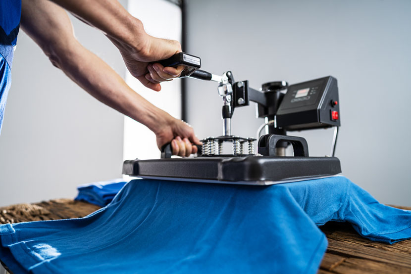 man printing on t shirt in workshop